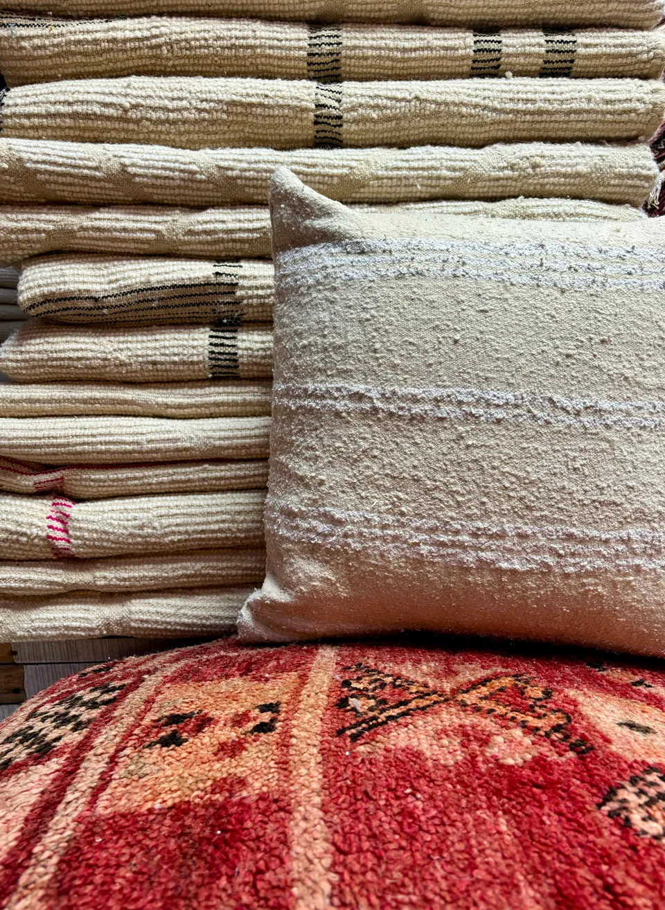 Pile de textiles chinés et coussin en laine, partagée sur Instagram